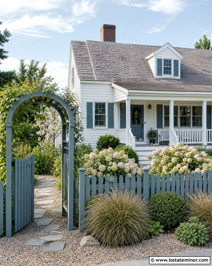 White Coastal Cottage With Blue Picket Fence - 30 White House Design With Fence Ideas